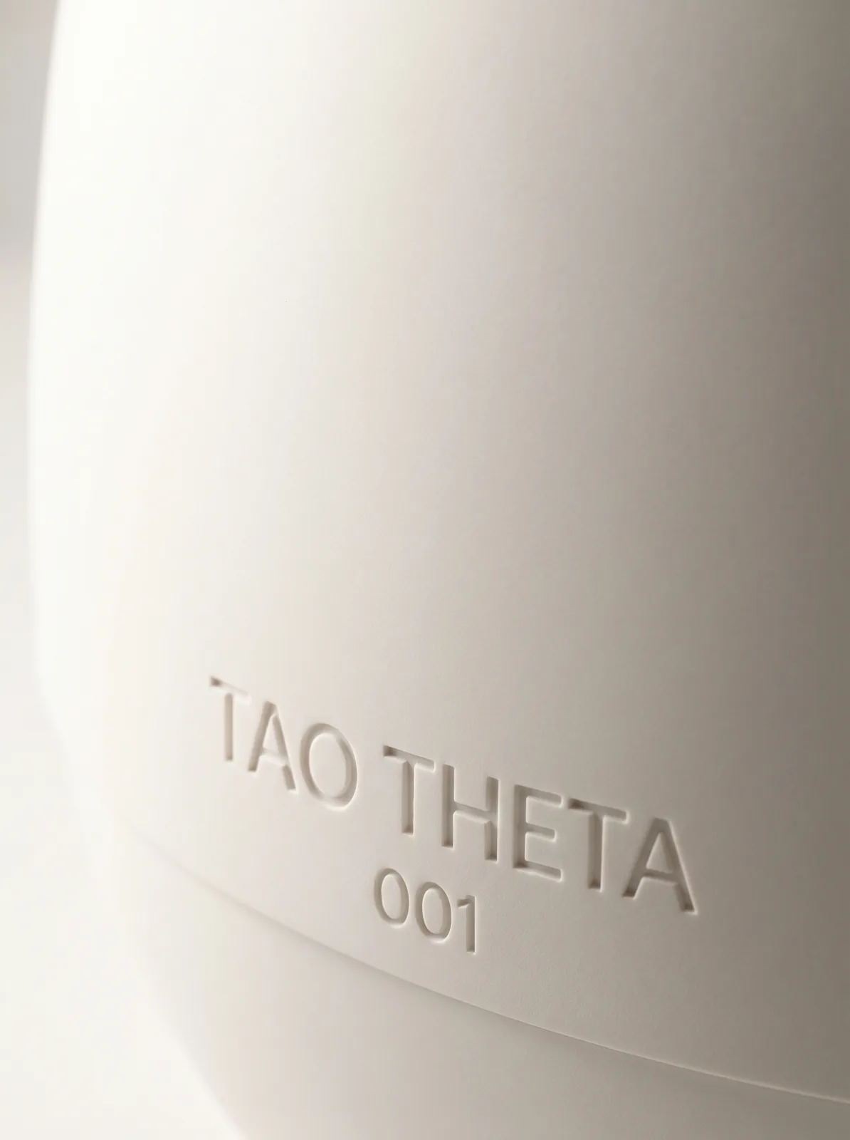 TAO THETA — scocca Corian bianco, scritta TAO THETA 001 in rilievo